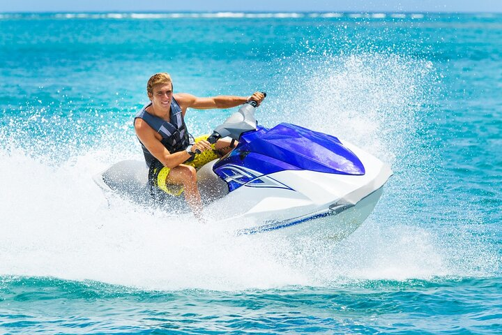 Soar above the Arabian Gulf enjoying an exhilarating ride on a jet ski while soaking in stunning views of Dubai's coastline and vibrant sea life making lasting memories.